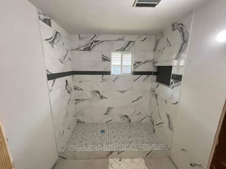 Marble tile shower with accent strip